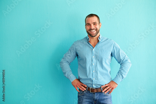 Fotografía Hombre feliz delante de la pared de color turquesa
