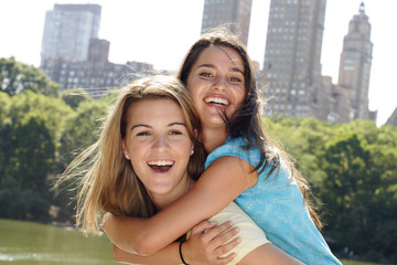 Two friends piggyback.