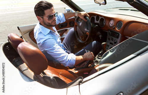Bel homme près de la voiture. Vie luxueuse. Poster