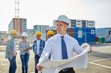 Wall Mural - architect with blueprint on construction site