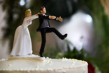 Bride catches groom wedding cake topper.