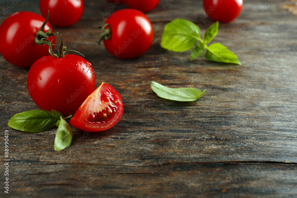 Cherry tomatoes with basil on wooden table close up