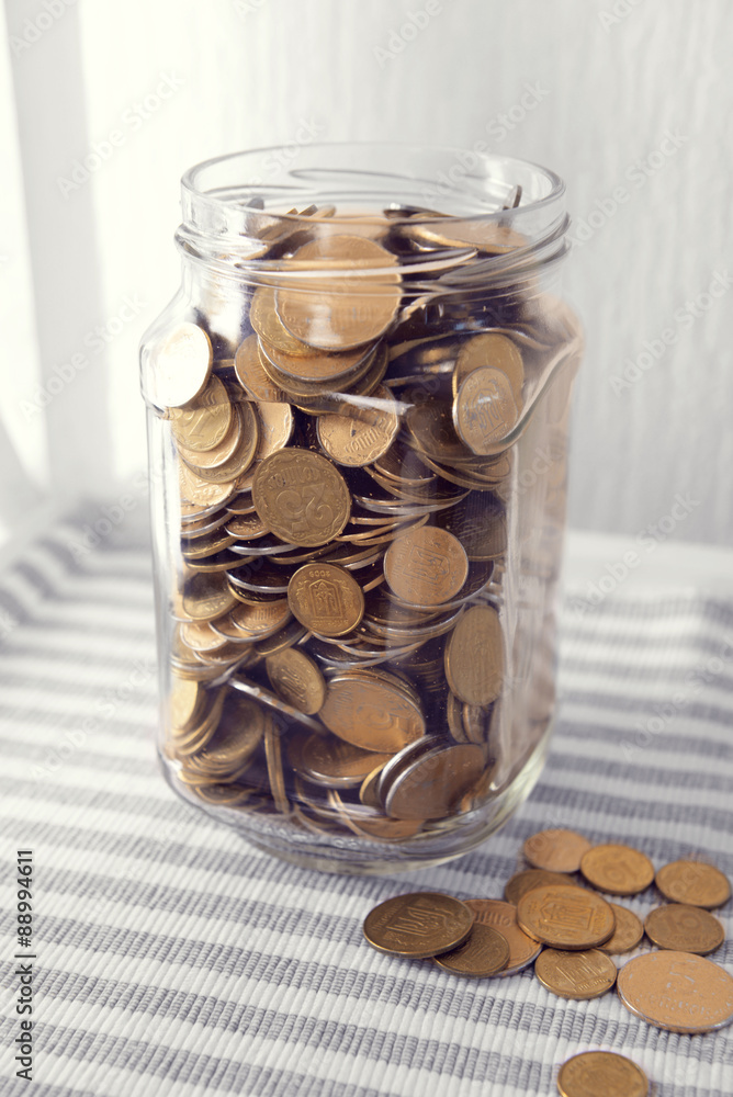 Coins in money jar on table close up