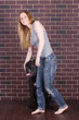 © victosha - girl in jeans standing near the wall and hugging a dog Cane Corso