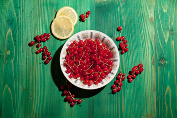 Canvas Print - red currants in white plate with lemon slice