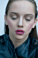 Wall Mural - Fashion girl with pink lips posing in black leather jacket