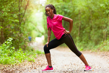 Wall Mural -  African american woman jogger stretching  - Fitness, people and