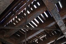 Underside Of Old Railroad Bridge Showing Rusty Steel Girders And Train Tracks