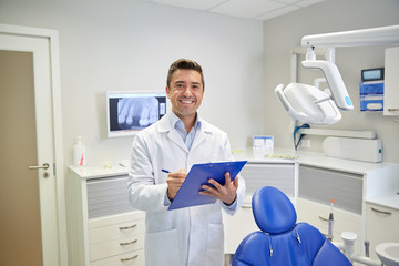 Poster - happy male dentist with clipboard at dental clinic