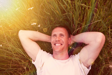 man lying on   green summer meadow.