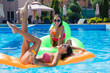 © Drobot Dean - Funny girls lying on air mattress in swimming pool