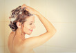© pathdoc - Smiling young woman washing head with shampoo in a shower  .