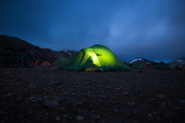 glowing tent stands in camping landmannalaugar, iceland.