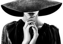 Beautiful Woman With Full Lips In Black Hat Poses On White