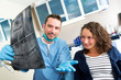 © Production Perig - Young attractive dentist showing x-ray to patient