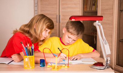 Two cute children working on their homework together. Education.