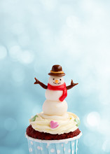 Cute Snowman Cupcake On Blue Bokeh Background