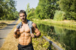 Muscular shirtless man outdoor by small river