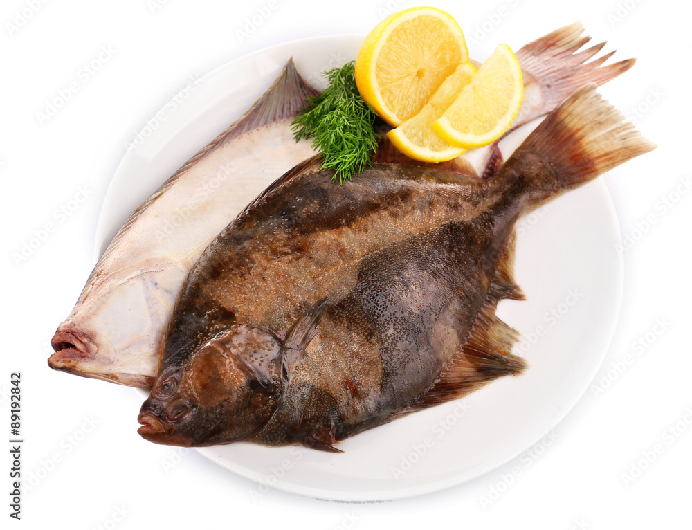 Fresh fishes with lemon on plate isolated on white