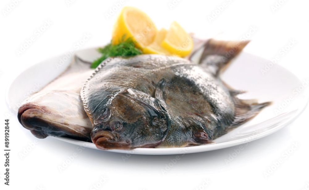 Fresh fishes with lemon on plate isolated on white