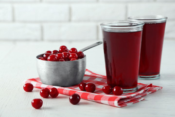 Two glasses with cherry juice on table, on light background