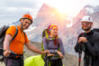 © alexbrylovhk - Cheerful mountain climbers portrait.Three people on mountain background man woman young old mature smiling and talking protection helmets backpacks and climbing gear mountain sunny background
