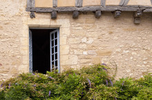 Window Decorated With Wisteria. An Old Historical Building In A Market Village In France Has A Window Decorated With Wisteria.