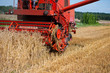 © esdras700 - Photo of combine harvester that is harvesting wheat with dust straw in the air.