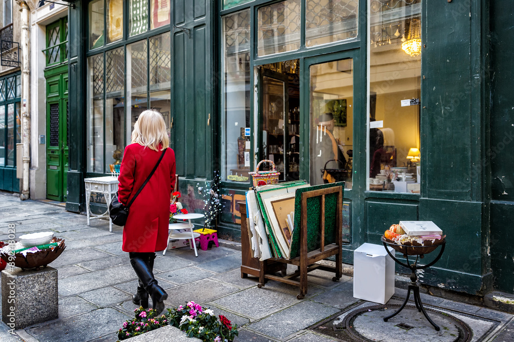 Paris street antique shop sidewalk shopper in red coat - obrazy, fototapety, plakaty 