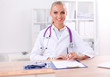 © lenets_tan - Beautiful young smiling female doctor sitting at the desk and