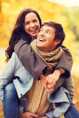 Canvas Print - smiling couple hugging in autumn park