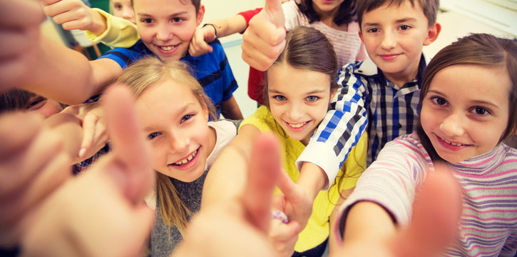 group of school kids showing thumbs up