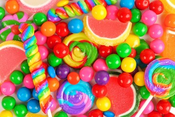 Colorful background of assorted candies including gum balls, lollipops and jelly candies