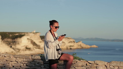 Wall Mural - Brunette girl reading or writing sms on sea background