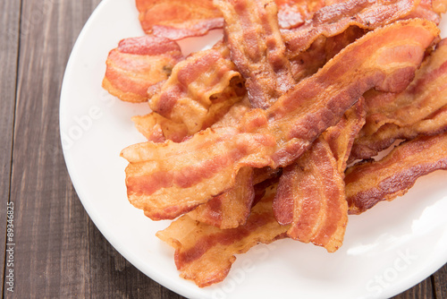 Fotografie, Obraz Closeup of fried bacon strips on white plate