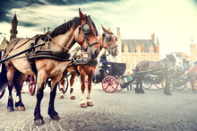 Horse-drawn Carriages On The Old Market Square. Bruges, Belgium