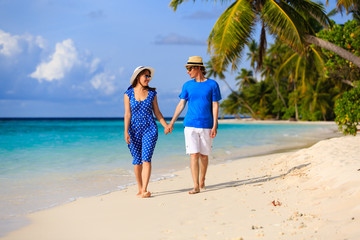 happy loving couple walking on tropical beach