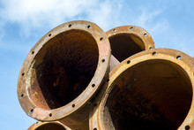 Rusted Industrial Steel Pipes On The Blue Sky Background.