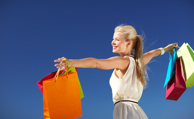 smiling woman with shopping bag rising hands