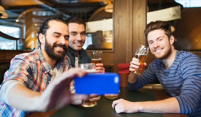 Wall Mural - male friends with smartphone drinking beer at bar