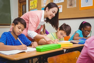 Wall Mural - Smiling teacher helping a student