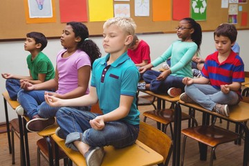 Pupils meditating on classroom desks