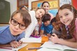 © WavebreakmediaMicro - Teacher and pupils working at desk together