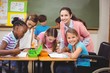 © WavebreakmediaMicro - Disabled pupil smiling at camera in classroom