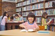 © WavebreakMediaMicro - Pupil smiling at camera in library