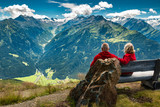 Fototapeta Góry - senior couple sitting in austrian alps and watching peaks with glacier and clouds