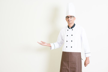 Wall Mural - Indian male chef in uniform welcoming