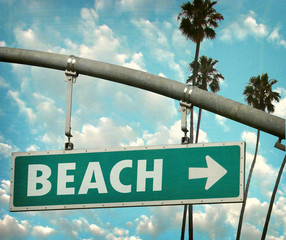 Wall Mural - aged and worn vintage photo of sign pointing to beach