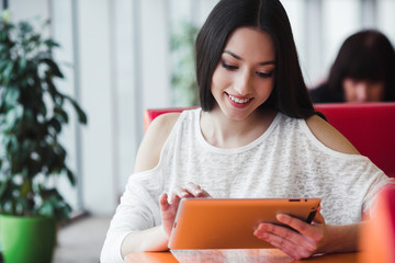Beautiful girl working on a tablet and smiling
