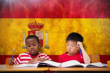 Canvas Print - Composite image of cute pupils writing at desk in classroom